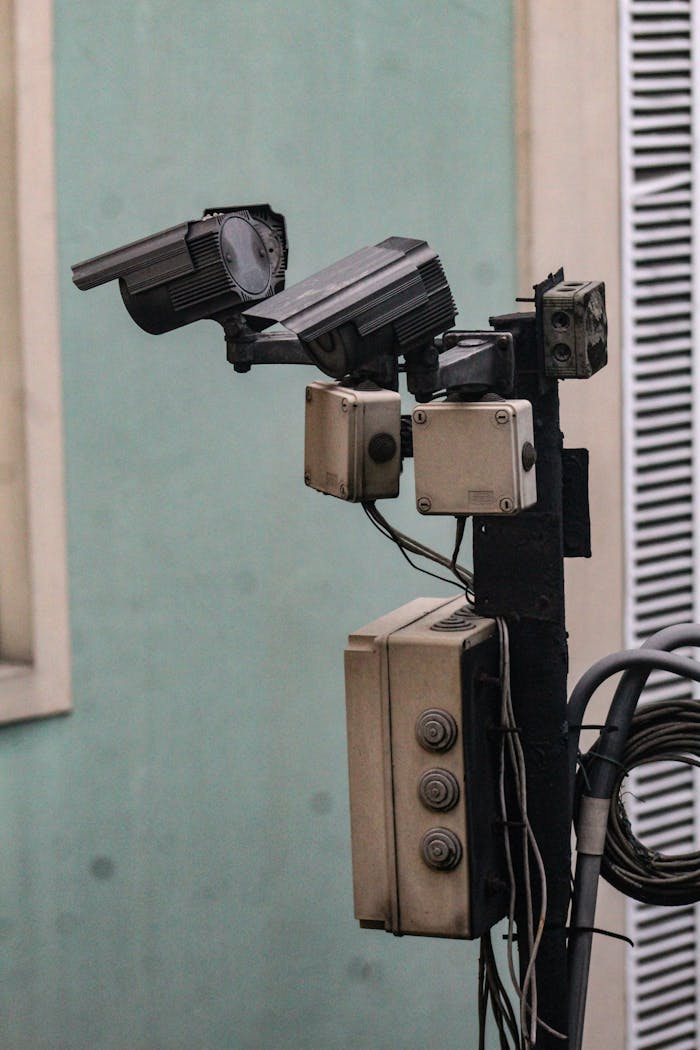 Close-up of CCTV cameras mounted on a pole for urban security monitoring.